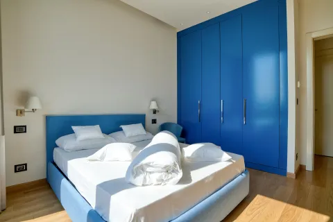 Modern bedroom with a double bed and a blue built-in wardrobe. - image 6