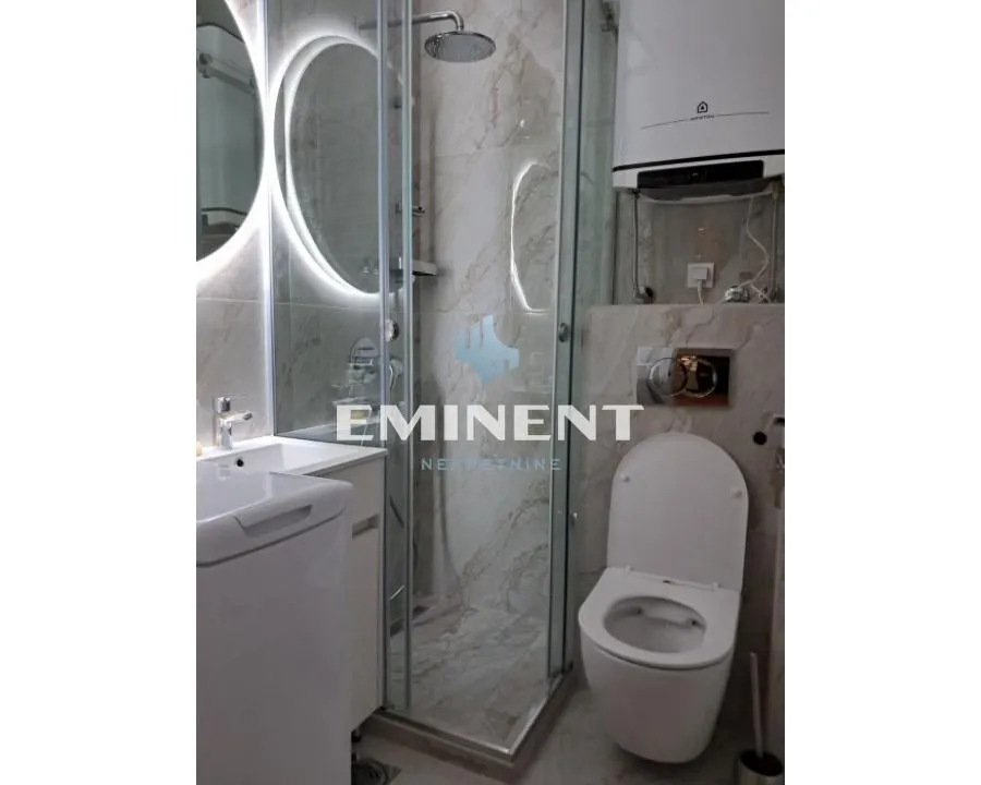 Modernly equipped bathroom with a shower cabin and built-in fixtures.