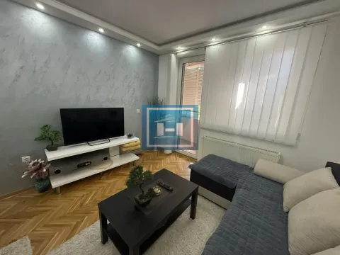 Dnevna soba sa ugaonom garniturom, televizorom i izlazom na terasu. - image 3
