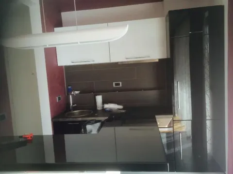 Moderna kuhinja sa tamnim elementima i belim gornjim ormarićima. - image 6