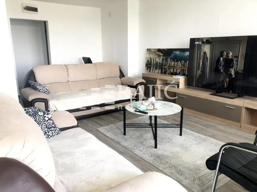 Furnished living room with sofa set and television.