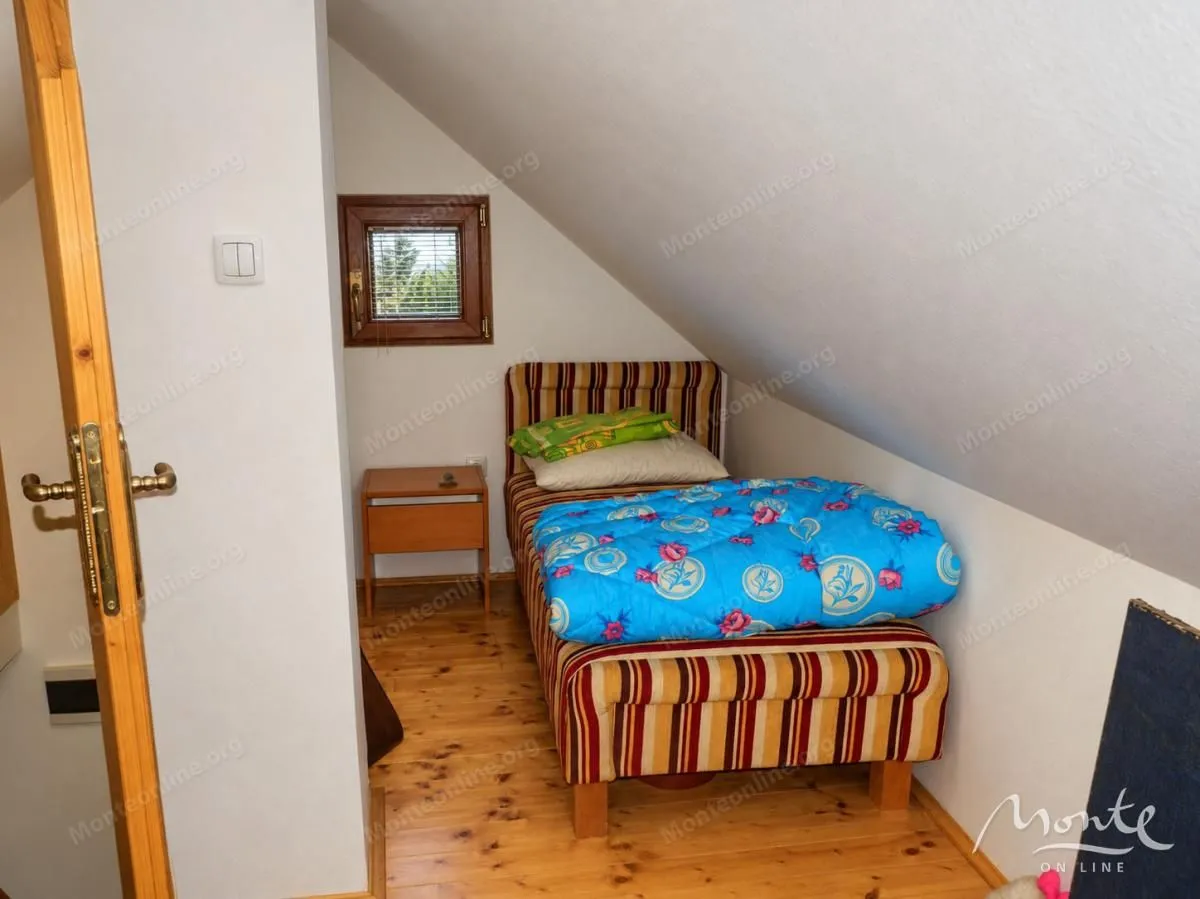 Smaller bedroom with a bed under a sloped ceiling.