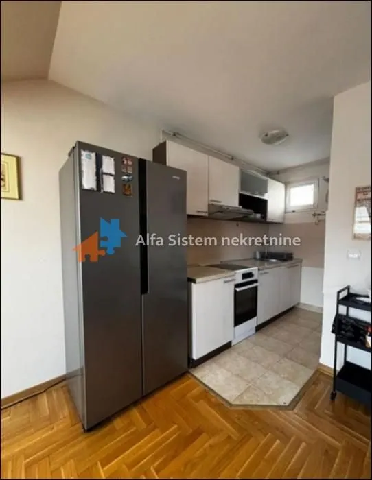 Smaller kitchen with white cabinets and a large refrigerator.