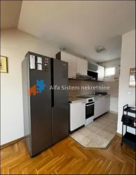 Smaller kitchen with white cabinets and a large refrigerator. - image 3