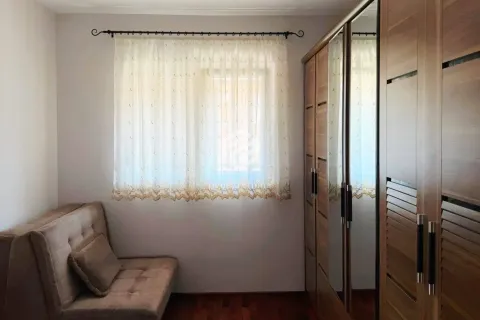 Bedroom with a bed, a window with curtains, and wooden wardrobes. - image 6