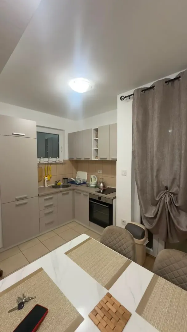 Small kitchen with a dining table and beige units.