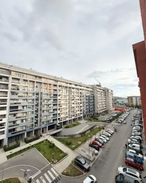 Pogled sa terase na stambenu zgradu i parking ispred objekta. - image 10