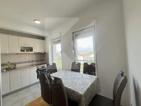 Kitchen with dining area equipped with white cabinetry and a dining table. - image 6