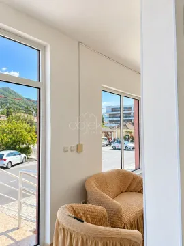 Living room with large windows and a view of the street. - image 2