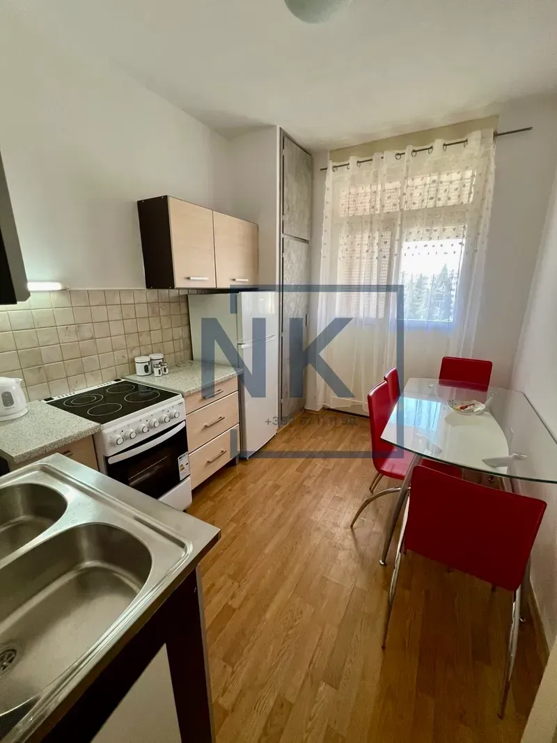 Small kitchen with a dining table and red chairs.