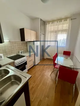 Small kitchen with a dining table and red chairs. - image 2