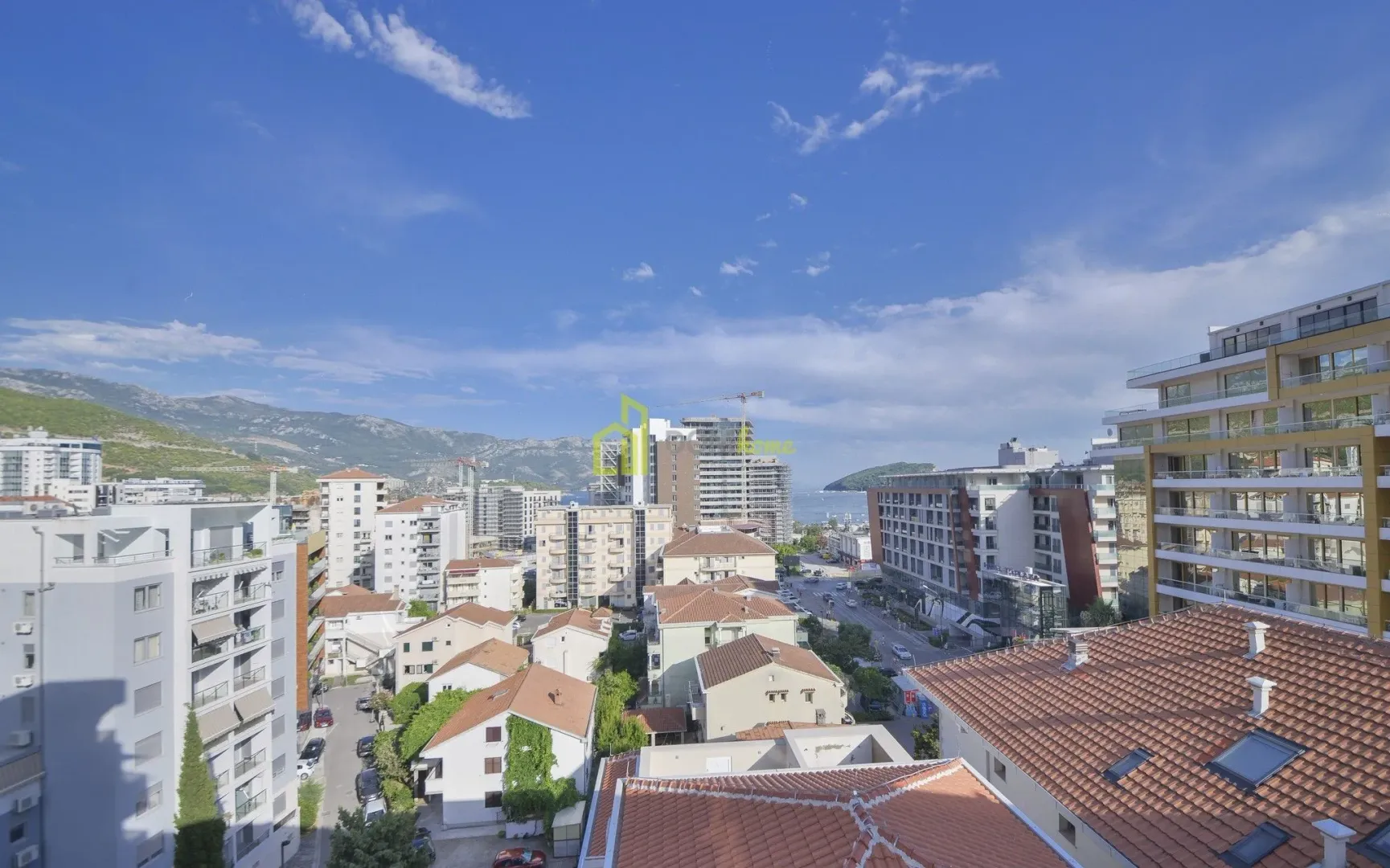 Pogled sa terase na gradske zgrade, planine i more.