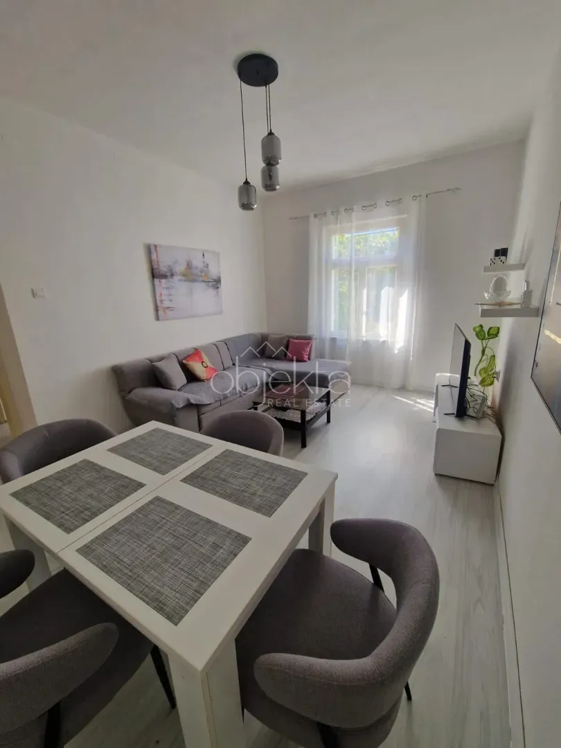 Living room with a sectional sofa, dining table, and TV.