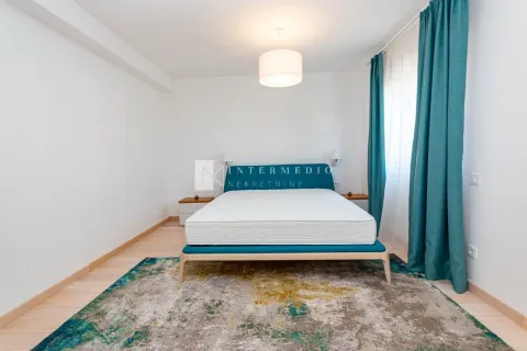 Svijetla spavaća soba sa bračnim krevetom, šarenim tepihom i plavim zavesama. - image 8