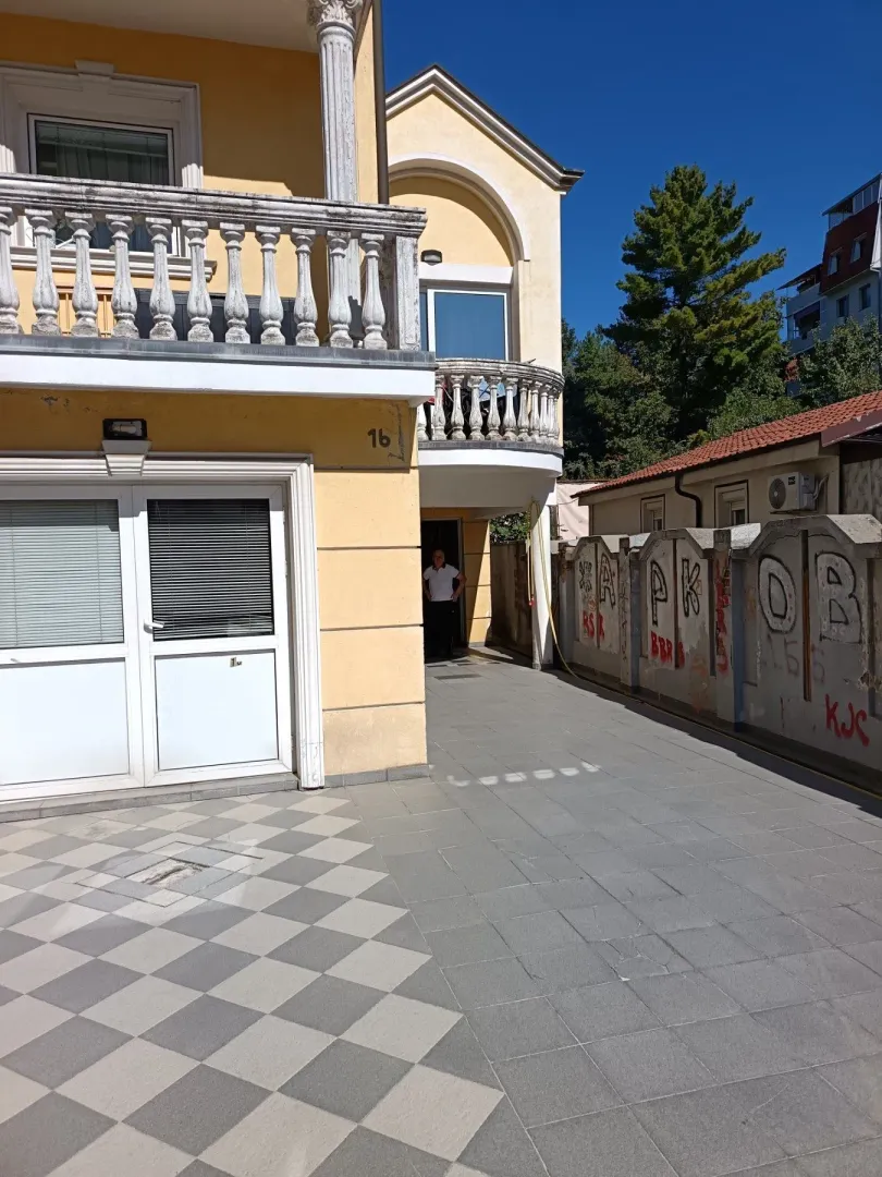 Eksterijer kuće sa dvorištem i balkonom.