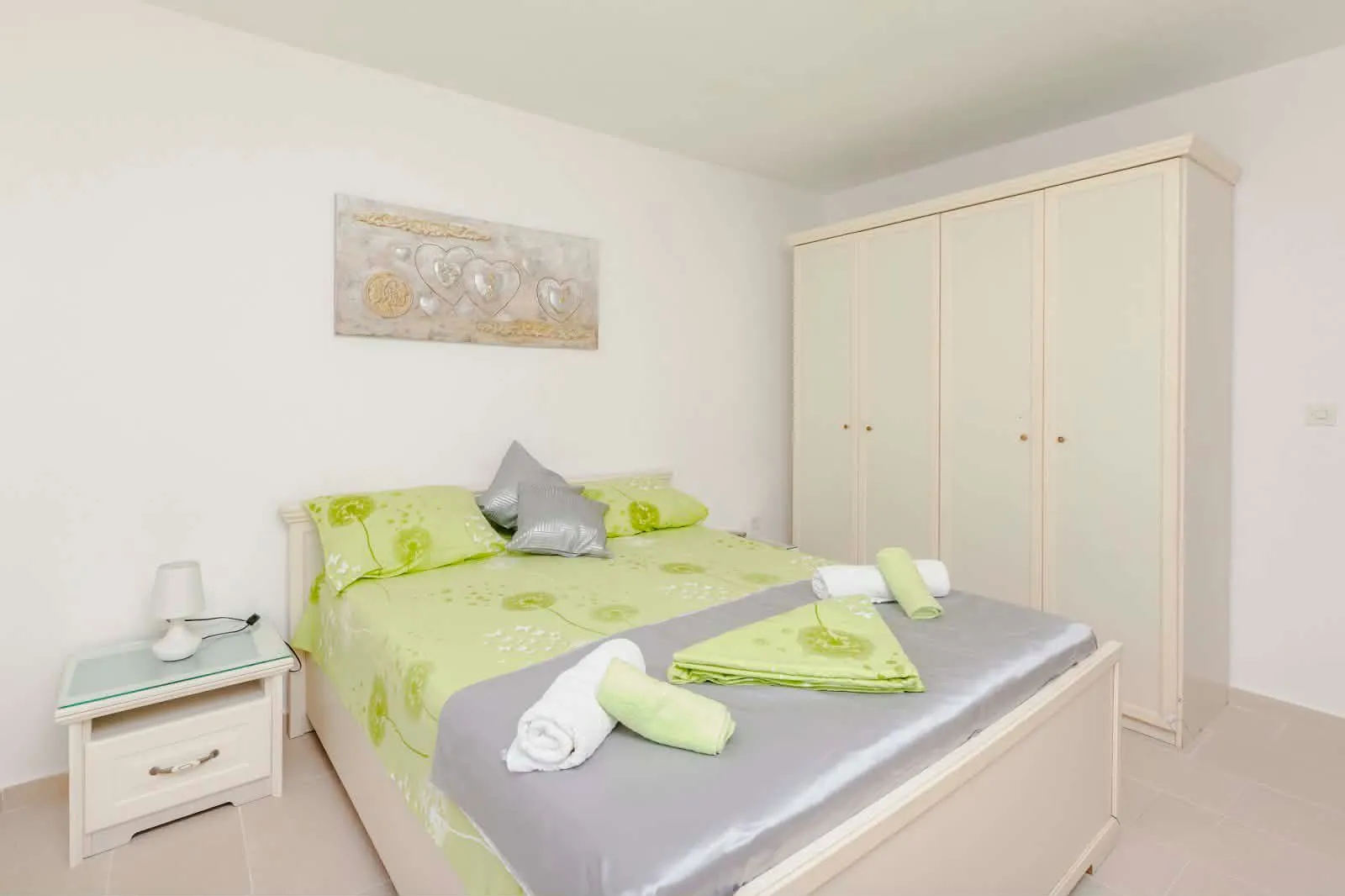 Bright bedroom with a double bed, wardrobe, and decorative details.