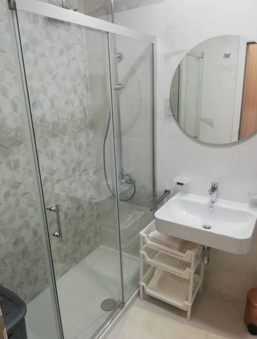 Modernly equipped bathroom with a shower cabin and a washbasin.
