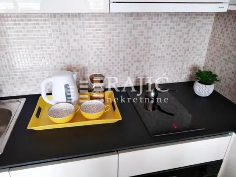 Detail of a modern kitchen with a countertop and home appliances. - image 11