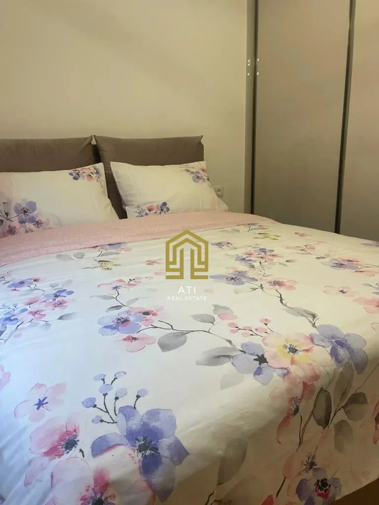 Furnished bedroom with a double bed and a wardrobe.