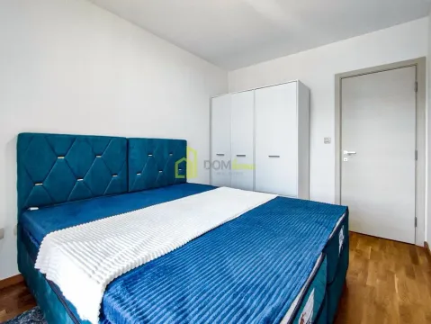 Bedroom with a large blue bed and white wardrobe. - image 12
