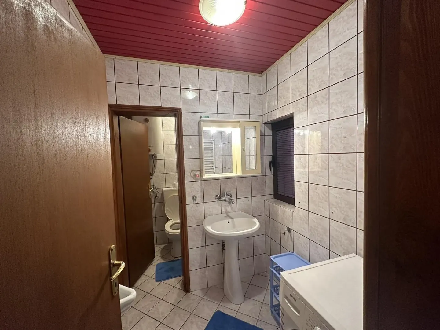 Jednostavno kupatilo sa lavaboom i ogledalom.