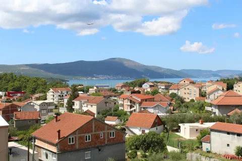 Pogled sa nekretnine na okolno naselje, more i planine u daljini. - image 2