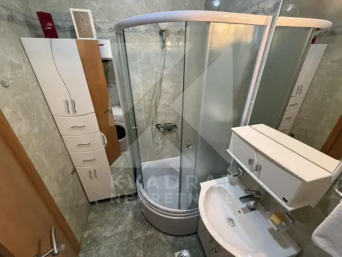 Bathroom with a shower cabin, washbasin, and cabinet. - image 11