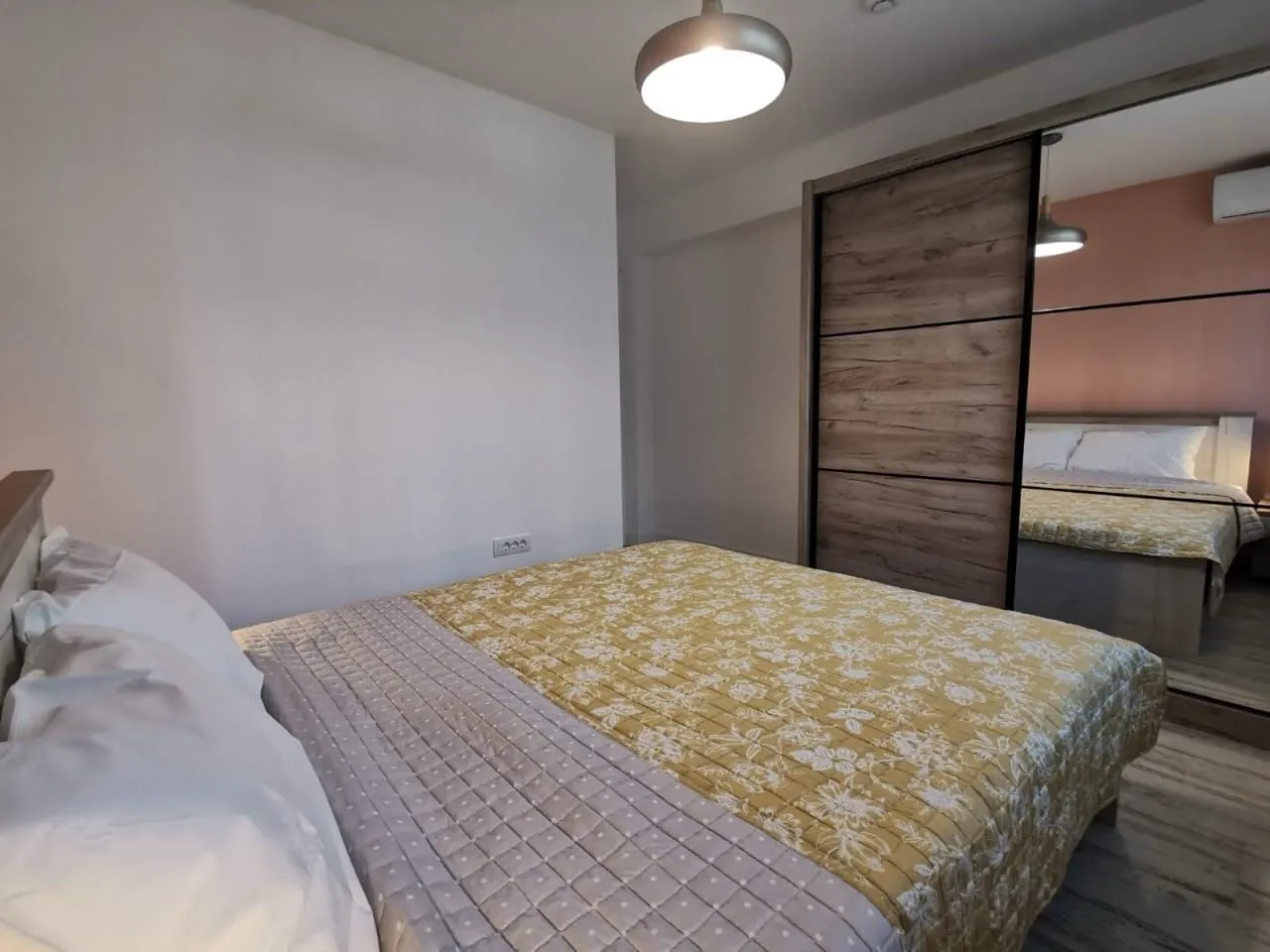 Bedroom with a double bed and a large mirrored wardrobe.