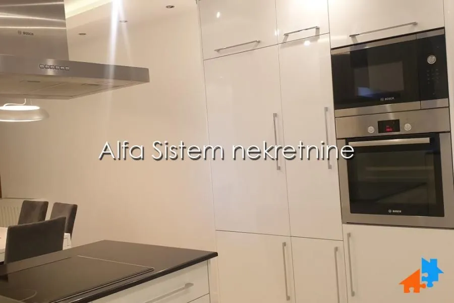 Modern kitchen with built-in appliances and white cabinetry.