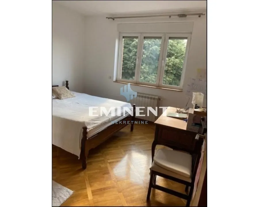 Furnished bedroom with a bed and a desk.