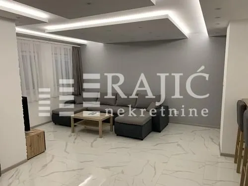 Modern and bright living room with a sofa and dropped ceiling.