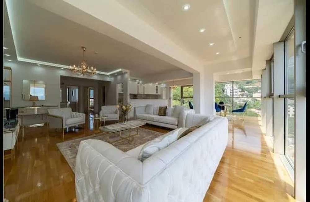 Spacious living room with seating area and large glass surfaces.