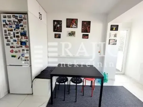 Dining area with a black table and chairs, connected to the kitchen. - image 2