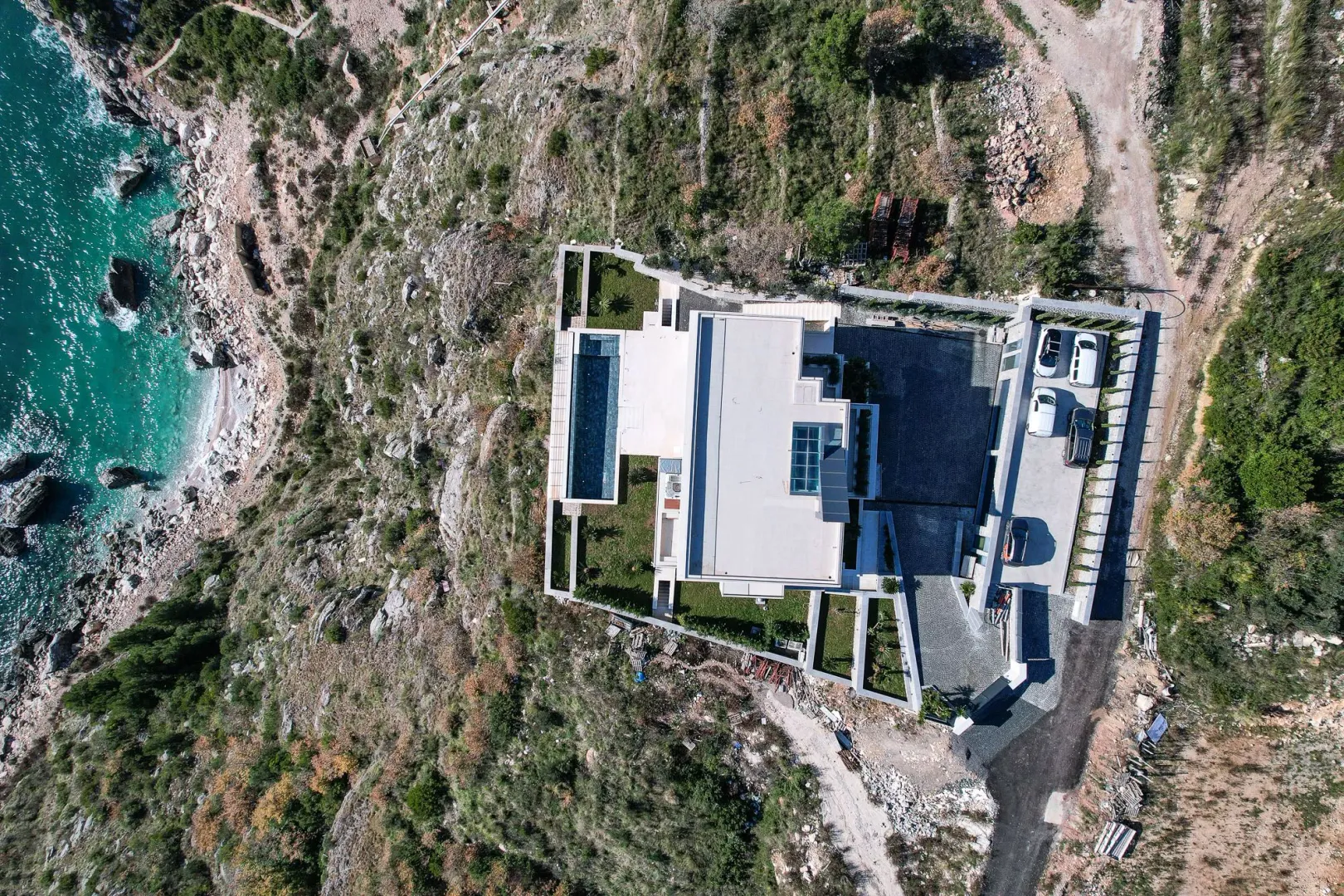 Pogled iz vazduha na vilu sa bazenom smještenu na obali mora.