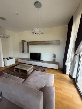 Living room furnished with a sofa, TV unit, and modern chandeliers. - image 2