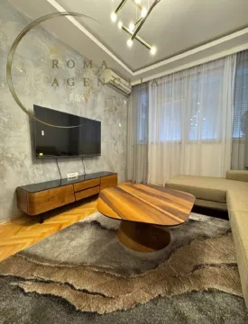 Living room with a sofa, TV, and decorative wall. - image 3