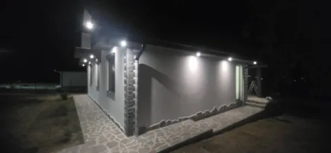 Noćni pogled na osvetljenu spoljašnost kuće sa popločanom stazom. - image 2