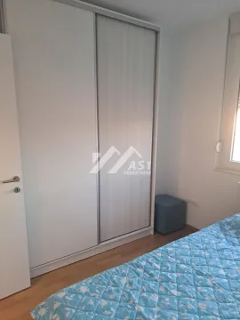Bedroom with a bed and a large white wardrobe. - image 6