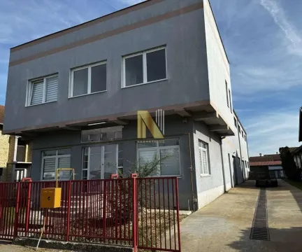 Exterior view of a two-story commercial building with a yard and fence. - image 12