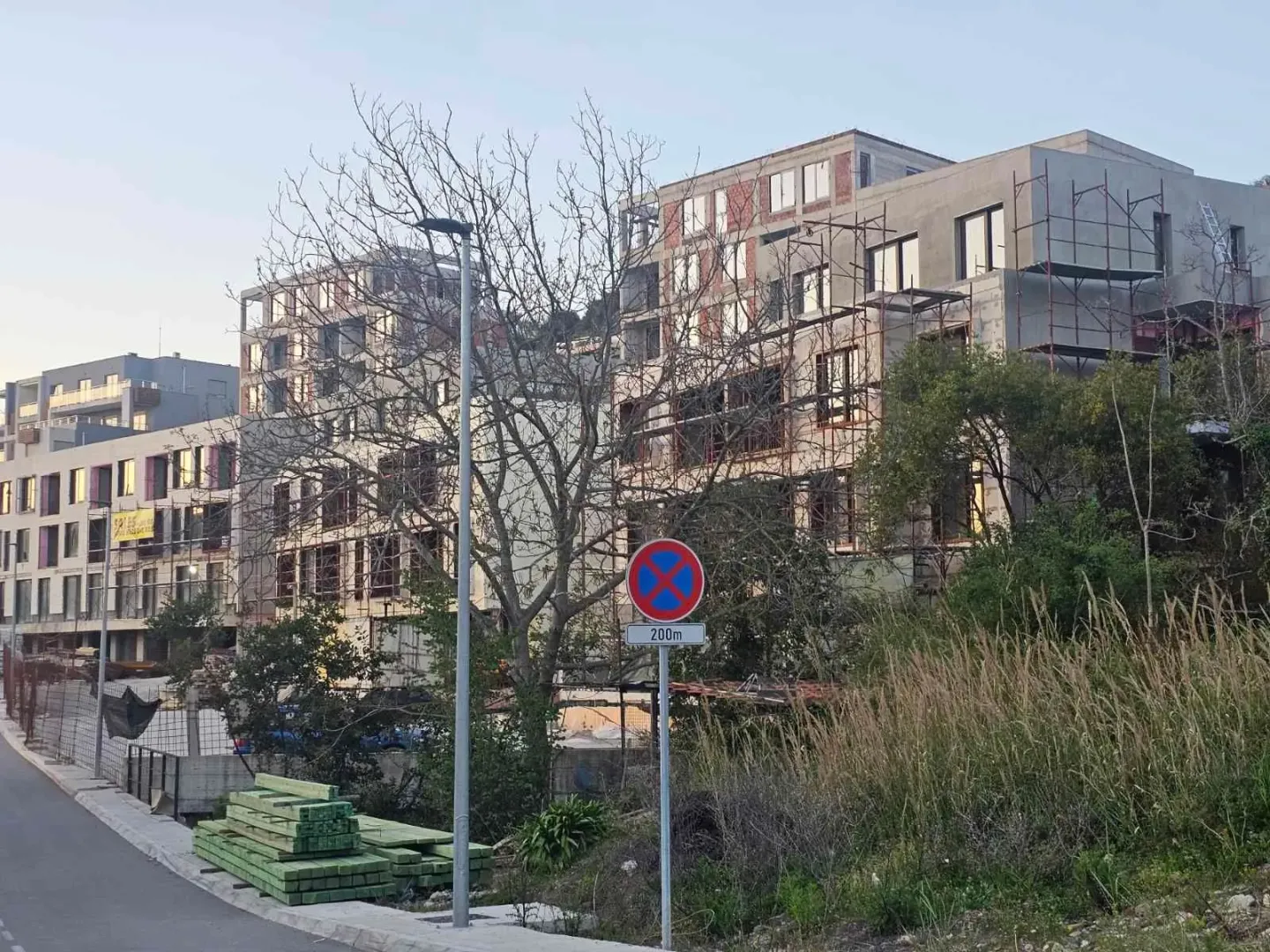 Spoljašnji pogled na stambenu zgradu u izgradnji sa skelama.