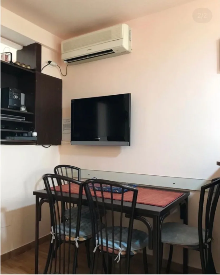 Dining area with a table, chairs, and a wall-mounted TV.