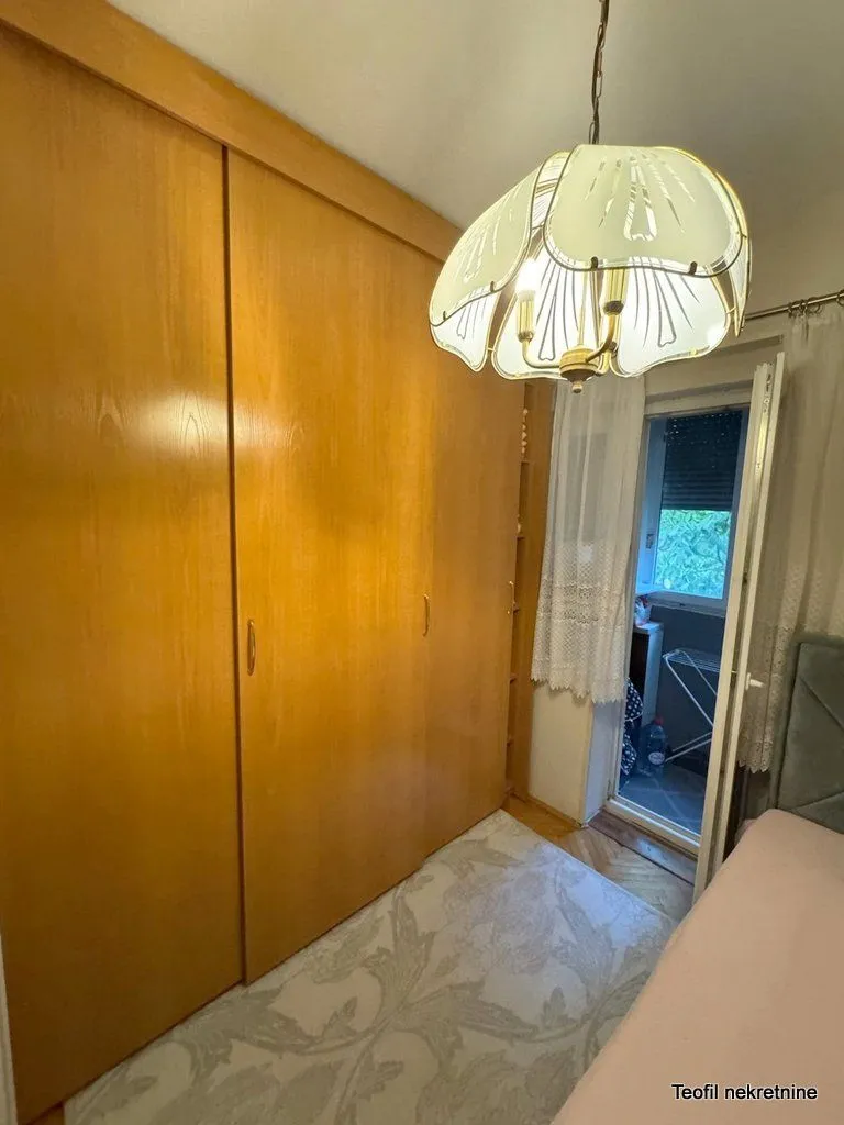 Bedroom with a large wooden wardrobe and access to the terrace.