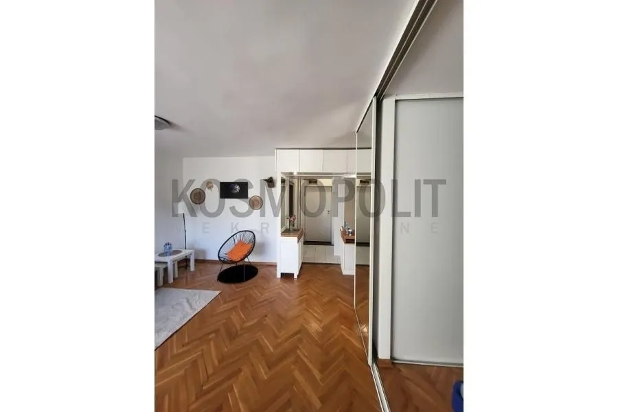 Pogled na dnevni boravak sa parketom i ugradnim ormarom.