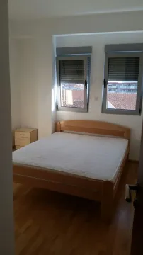 Simply furnished bedroom with a wooden double bed. - image 15
