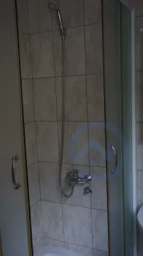 A simple shower cabin with light tiles in a bathroom. - image 16