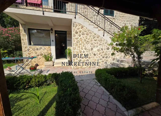 Eksterijer kamene kuće sa dvorištem i spoljnim stepeništem.