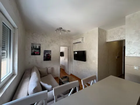 Bright living room with a sofa and TV. - image 2
