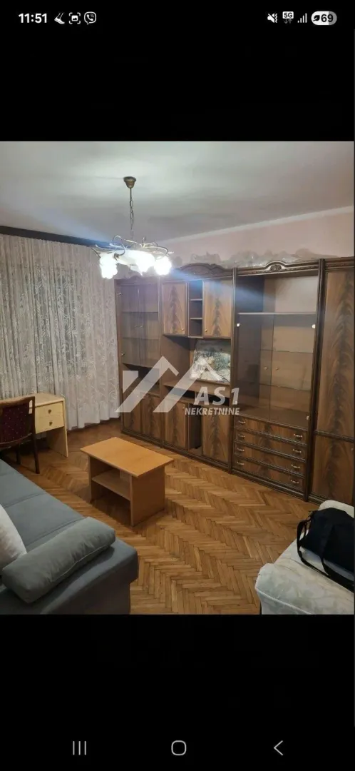 Dnevna soba sa garniturom, drvenim nameštajem i parketom.
