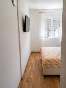 Manja spavaća soba sa bračnim krevetom i prozorom. - image 5