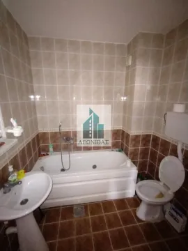 Bathroom equipped with a bathtub, washbasin, and toilet featuring ceramic tiles on the walls and floor. - image 14